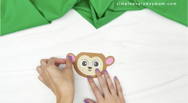 hand gluing inner ear to monkey card craft