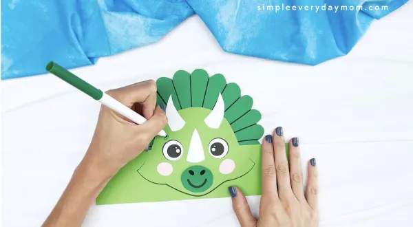 hand drawing eyebrow onto dinosaur headband