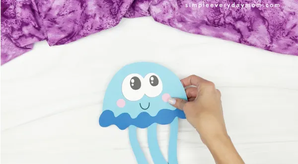 hand gluing tentacles to jellyfish headband craft