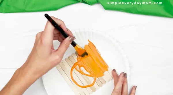 hand painting popsicle sticks orange