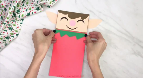 hand gluing shirt trim to paper bag elf craft