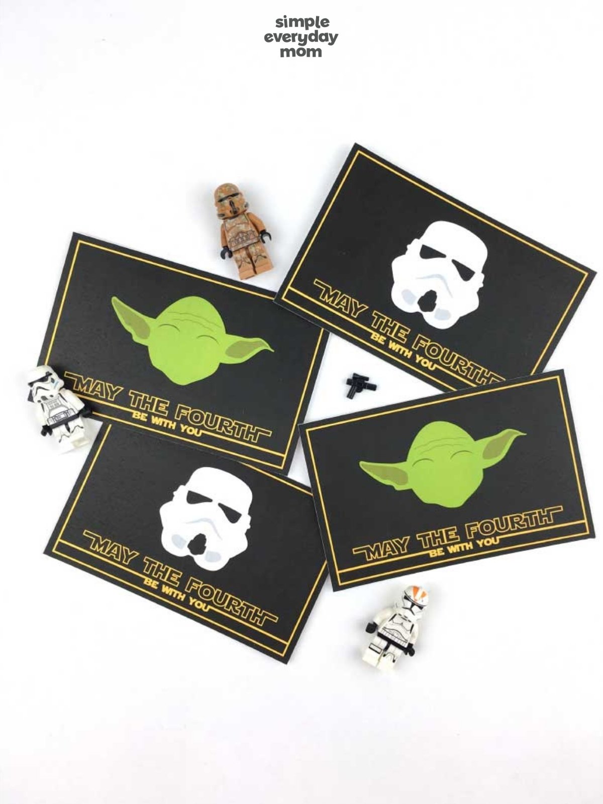 Four Star Wars-themed “May the Fourth be with you” cards with Grogu and stormtrooper helmet designs, surrounded by small toy figures.