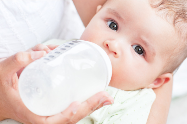 closeup of baby drinking a bottle