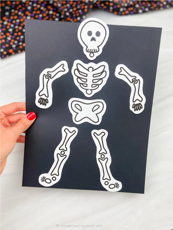 hand holding skeleton paper craft