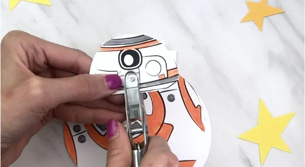 hand punching a hole in bb-8 card craft