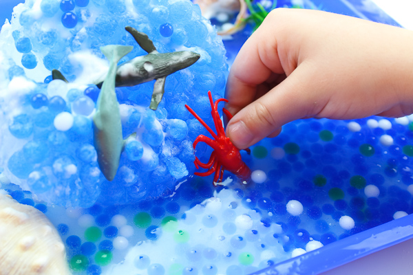 Ocean Theme Preschool Play | Kids will love uncovering their favorite ocean animals in this frozen ocean small world activity. #sensorytubs #sensoryactivities #stemactivities #scienceactivities #preschoolscience