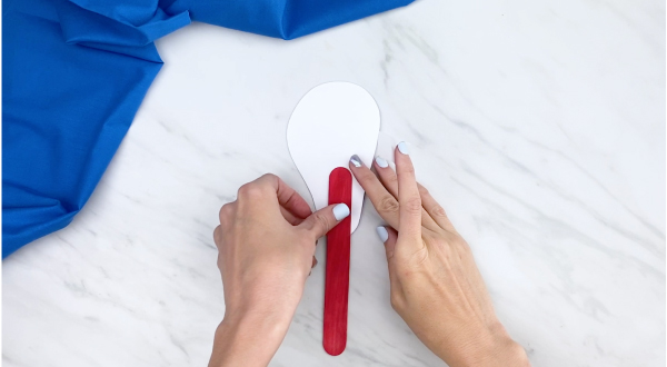 hand gluing ear puppet to jumbo red popsicle stick