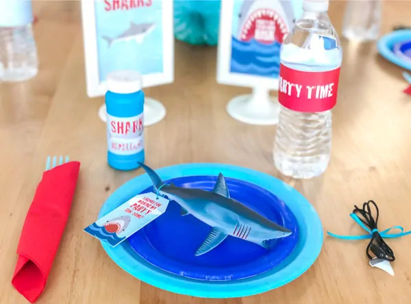 Shark Party Ideas | Create a simple but cool shark table setting with solid colored paper plates, a shark toy favor, napkins and some decorations. #partyideas #partyplanning #boysbirthday #birthdayparty