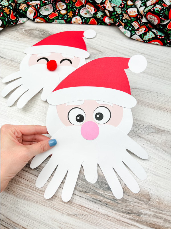 hand holding Santa handprint craft with a second one in the background