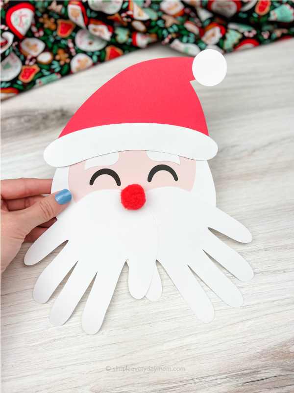 hand holding Santa handprint craft
