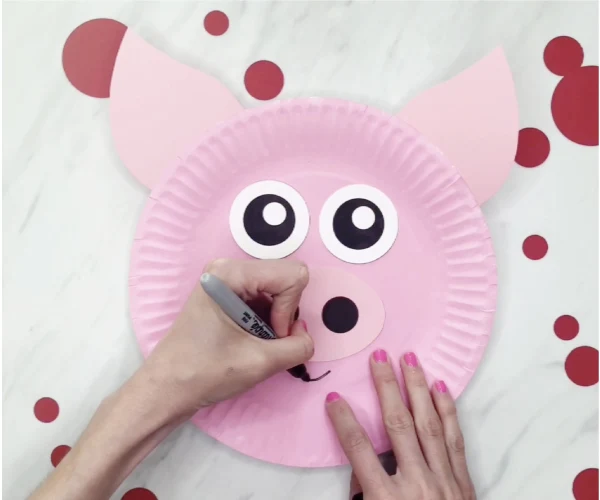 hand drawing mouth onto paper plate pig craft