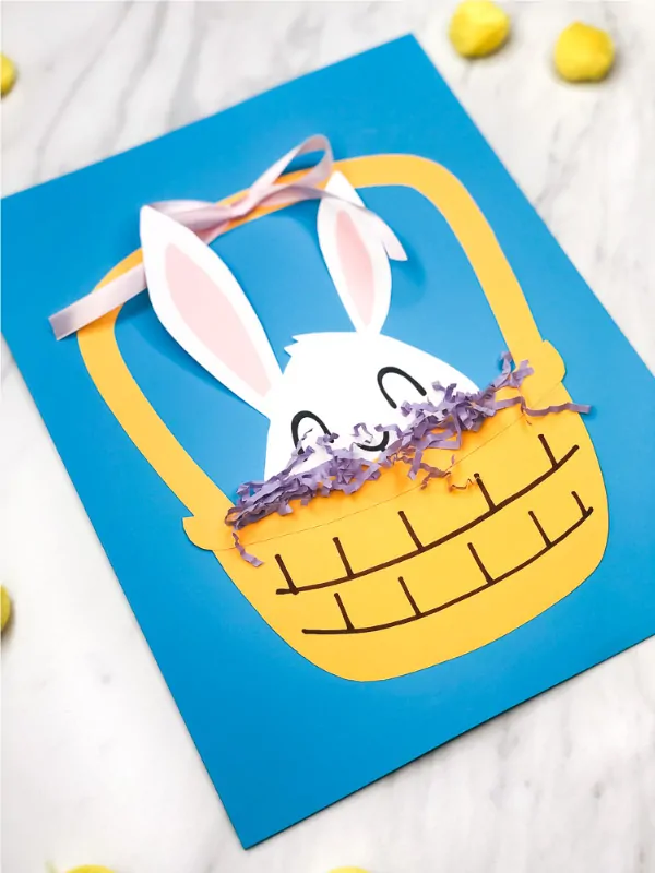 Easter Bunny Craft For Kids | Make this peek a boo Easter craft with some paper, ribbon and Easter grass. It's and easy DIY and comes with a free printable template. #kids #kidscrafts #craftsforkids #ece #earlychildhood #preschool #teachingkindergarten #teacher #classroom #papercraft #easter #eastercrafts #eastercraftsforkids