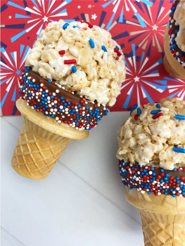 Independence Day Dessert Ideas For Kids | Kids will love helping you make these patriotic rice krispie "ice cream" cones that are simple and fun to make. They're a great 4th of July dessert that won't melt! #dessertrecipes #4thofjuly #dessertideas #ricekrispietreats #nobakedesserts #desserts #partyfood #partyideas