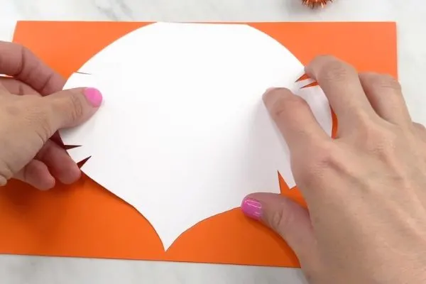 hand tracing lion mane on orange paper 
