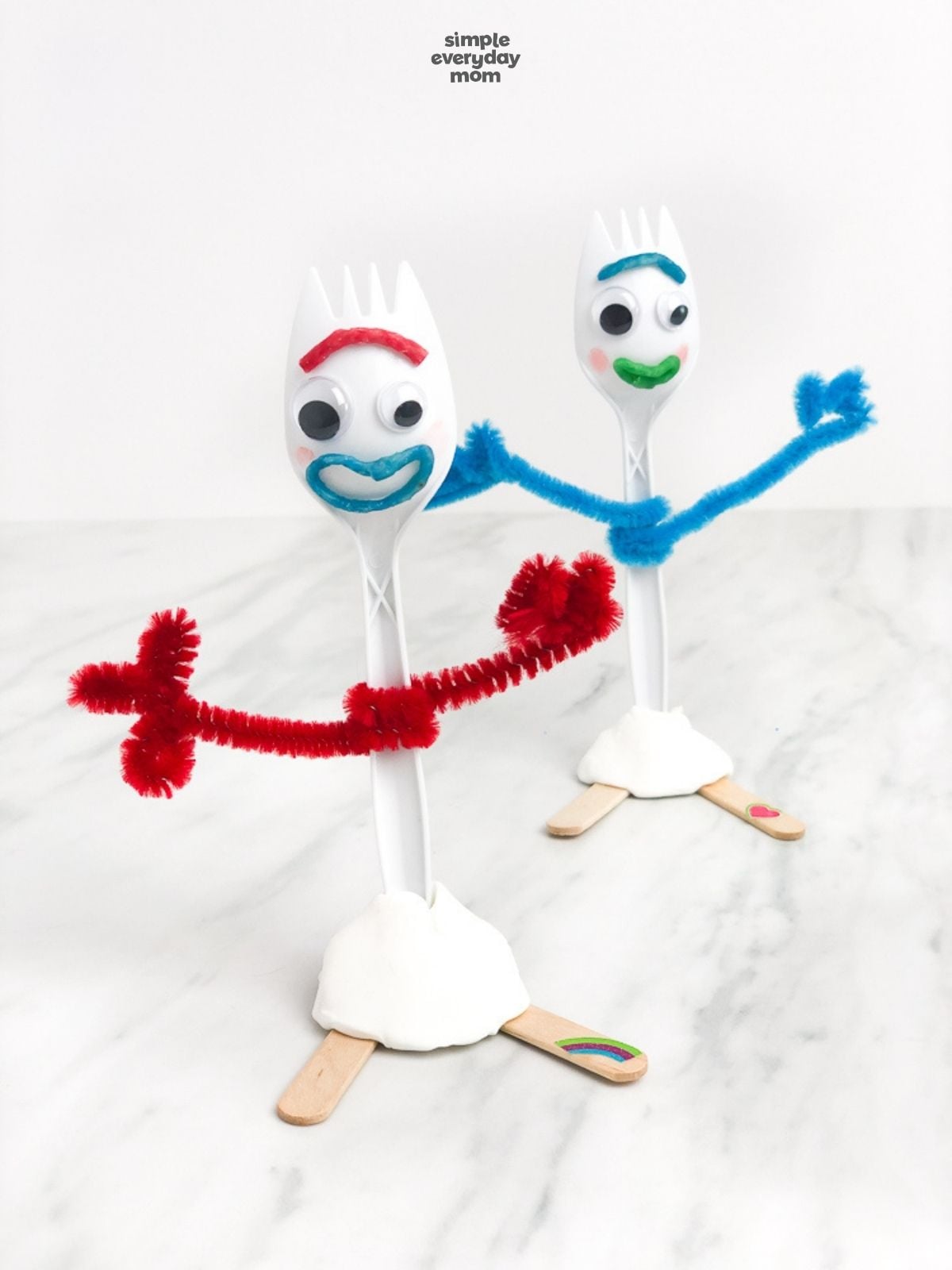 Two finished Forky crafts displayed together with red and blue pipe-cleaner arms.