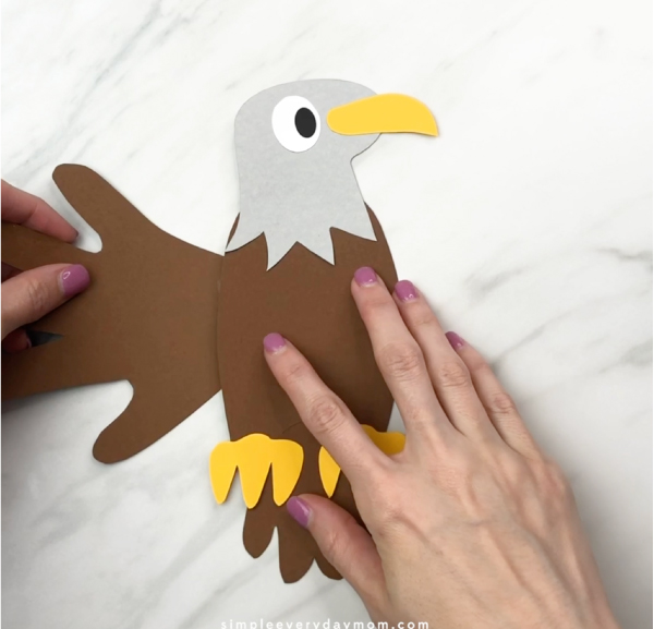 hand gluing handprint wing to handprint eagle craft