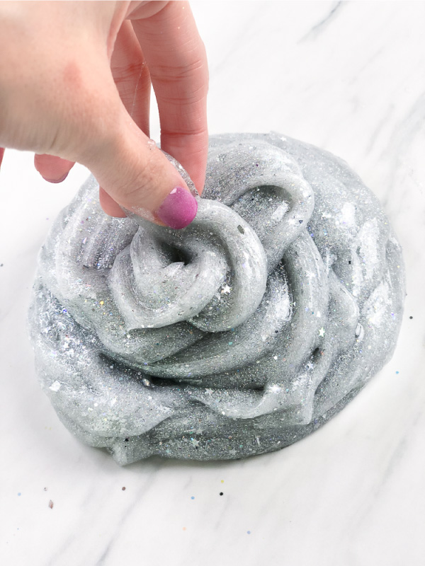 hand with swirl of silver glitter slime
