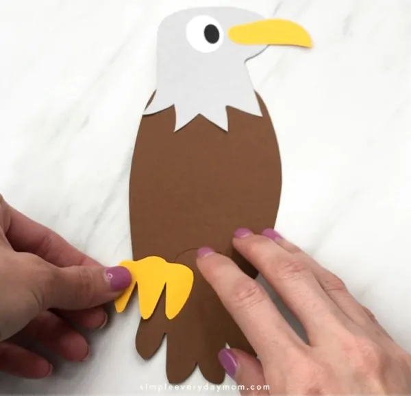 hand gluing on paper eagle claws