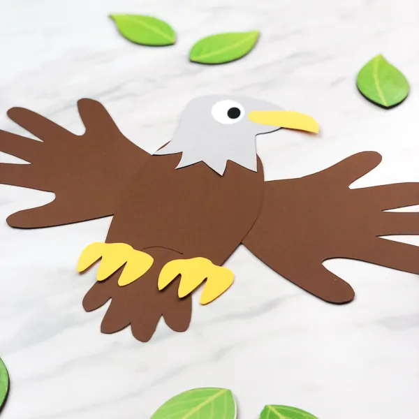 eagle paper craft surrounded by wooden leaves