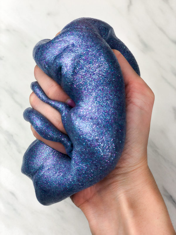 hand squeezing galaxy slime