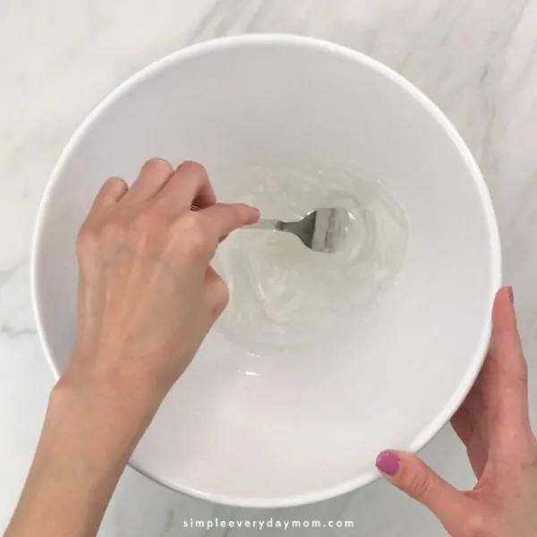 hand mixing clear slime