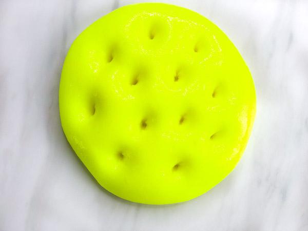 neon yellow slime with holes poked in it 