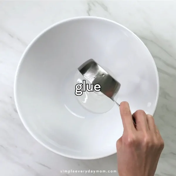 hand pouring glue into white bowl
