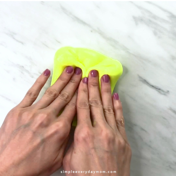 hands kneading yellow slime