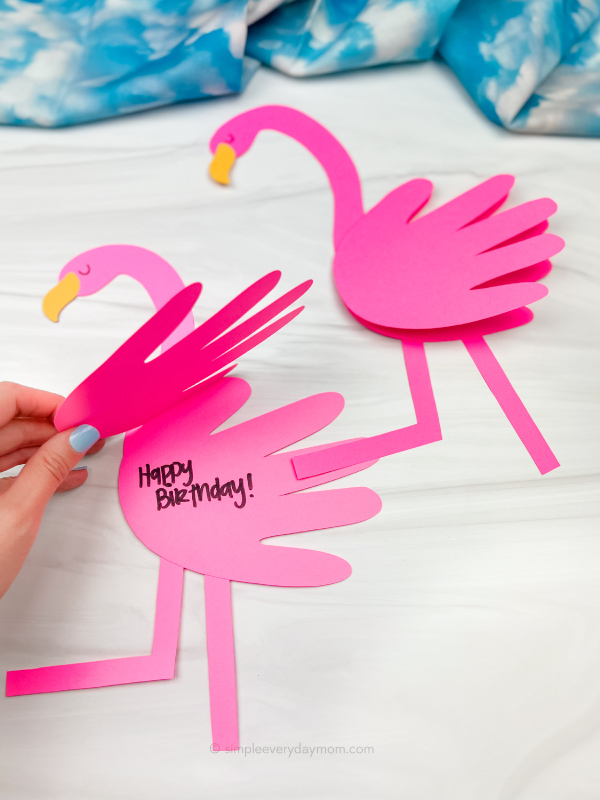 hand opening flamingo handprint card craft with another one in the background