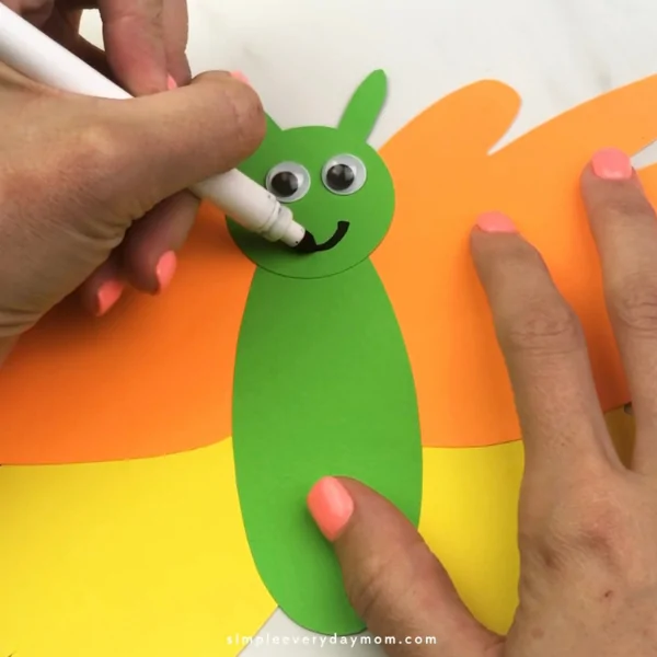 hand drawing smile onto handprint butterfly craft