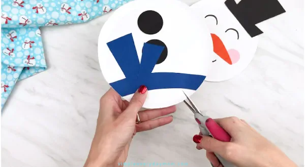 Hands making slit into paper plate with scissors 