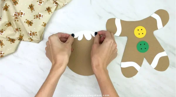 hand gluing icing hair to paper bag gingerbread craft