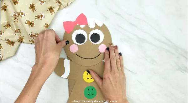 hand gluing head to paper bag gingerbread craft