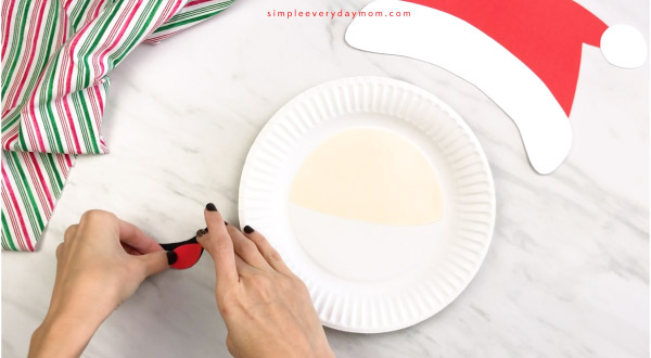 hands gluing Santa paper plate craft mouth