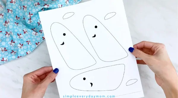 Hands holding narwhal craft template 