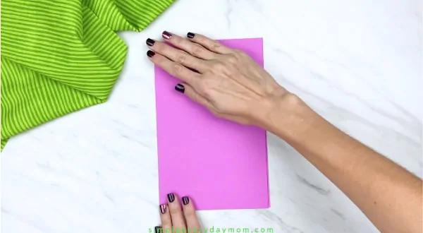 hands folding pink paper
