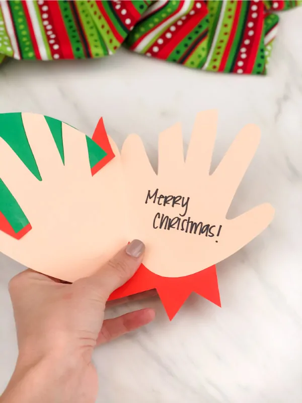 Hand holding open handprint elf card craft 