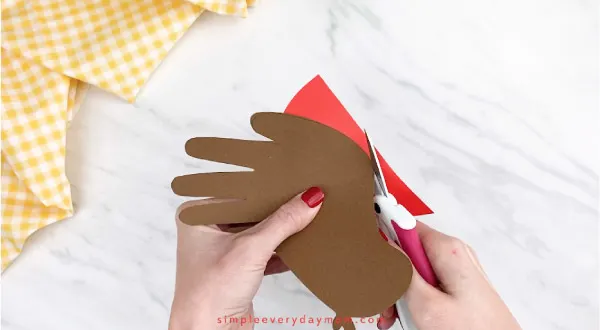 hands cutting red paper 