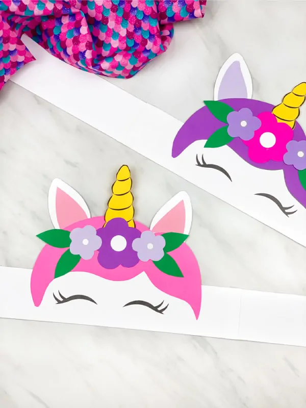 Pink and purple unicorn headbands laying flat on the table. 