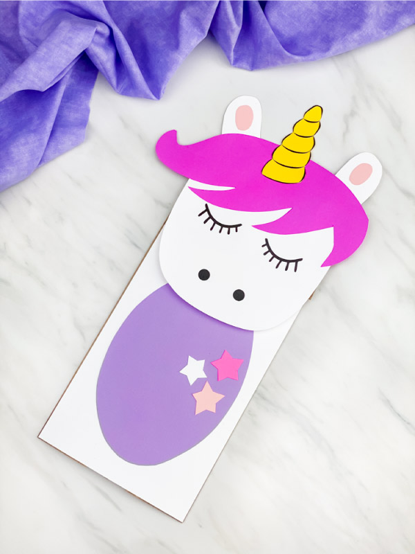 paper bag unicorn craft with vibrant pink hair and purple belly 