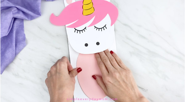 hands gluing belly onto paper bag unicorn craft
