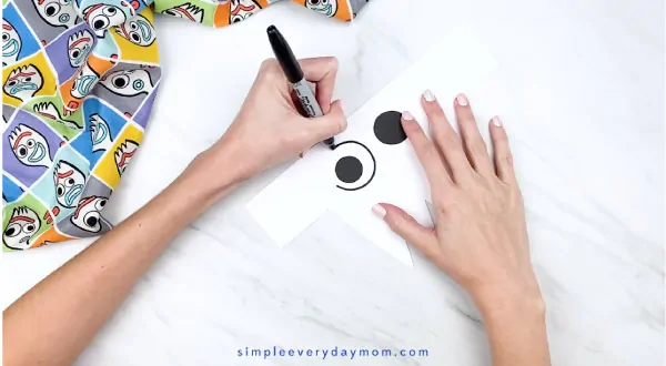 hands outline paper eye with black marker
