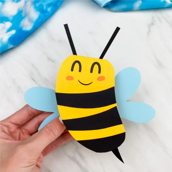 Hand holding paper bee card craft 