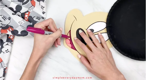 hands coloring in mouth with red marker 