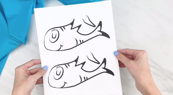 Hands holding Dr. Seuss fish craft template 
