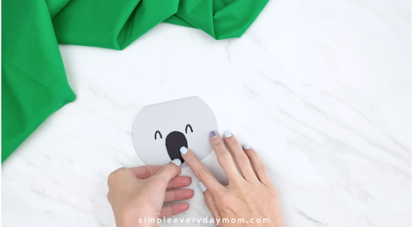 hands gluing on koala nose to paper craft 