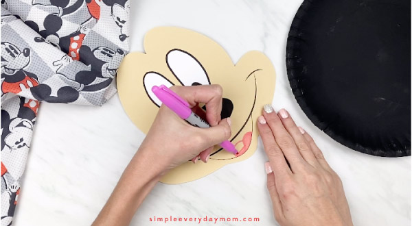 hands coloring in Mickey Mouse\'s tongue