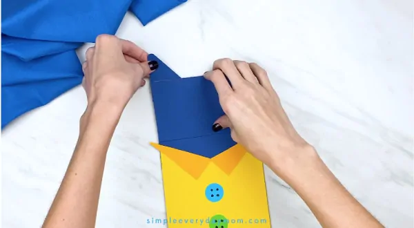 hands gluing paper Pete the Cat ears onto craft