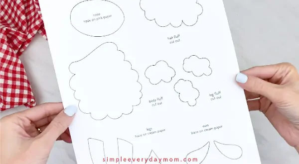 Hands holding paper sheep craft template 