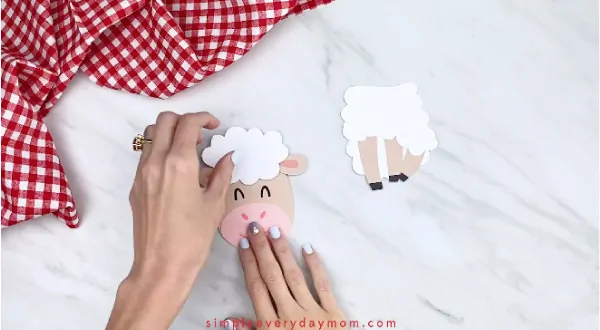 Hands gluing fluff onto paper sheep card craft 